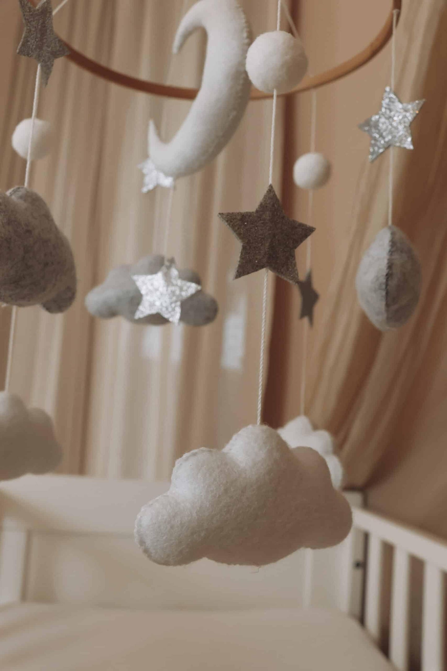 Mobile bébé nuage, lune et étoiles en feutrine suspendu au-dessus d’un lit enfant