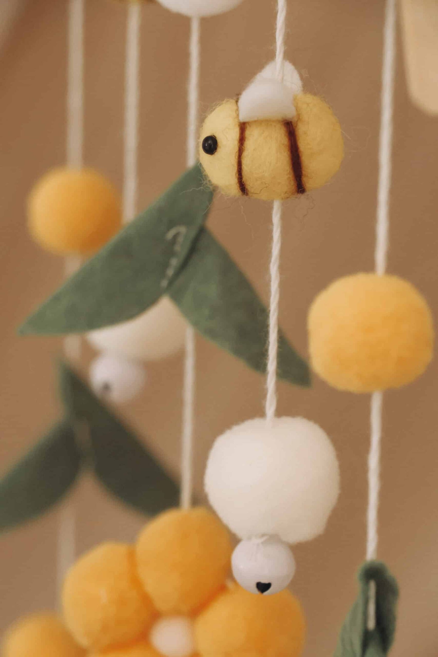 Mobile bébé en laine feutrée avec abeille, fleurs jaunes et feuilles vertes décoratives