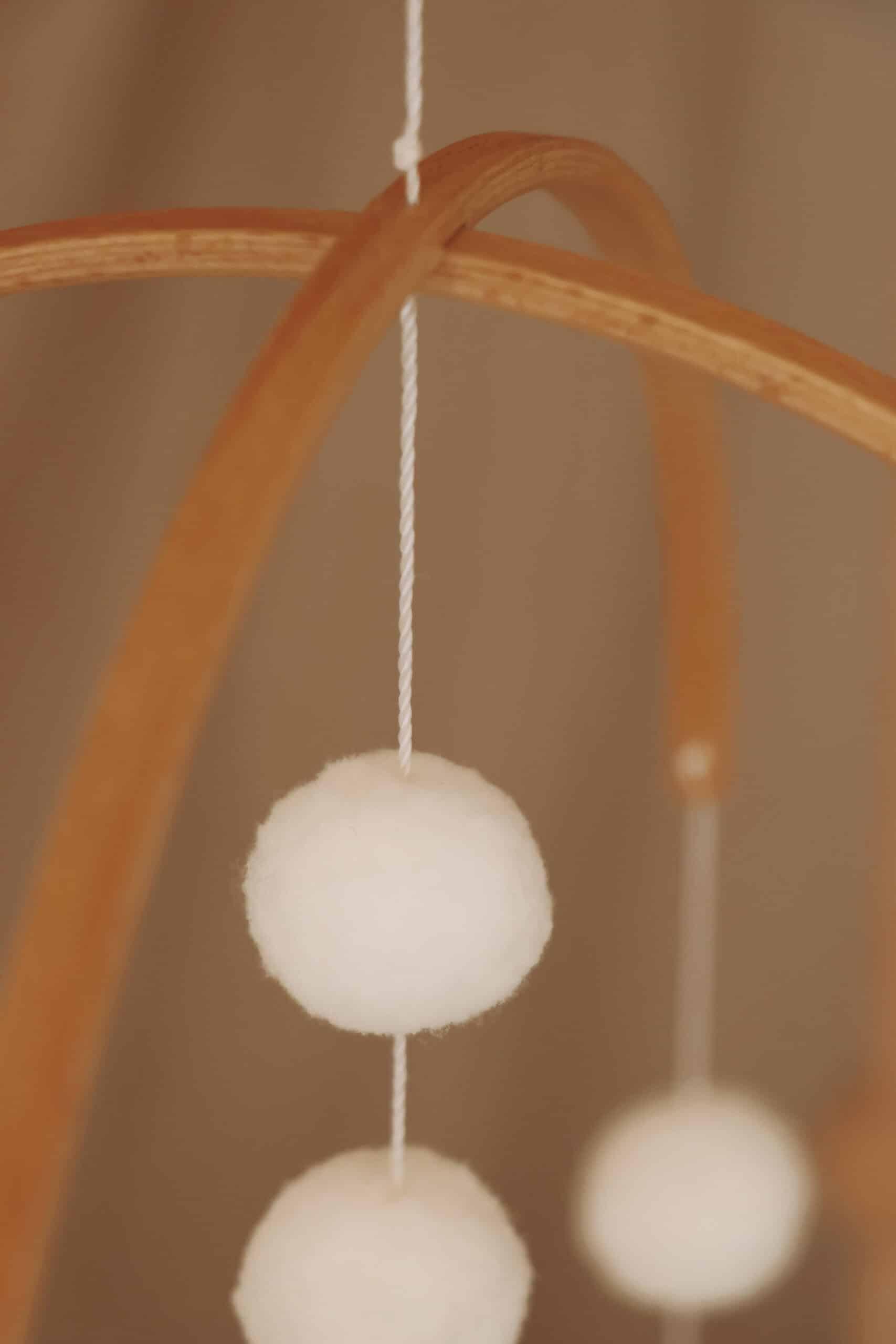 Mobile pour bébé en bois et pompons blancs suspendus, décoration chambre enfant