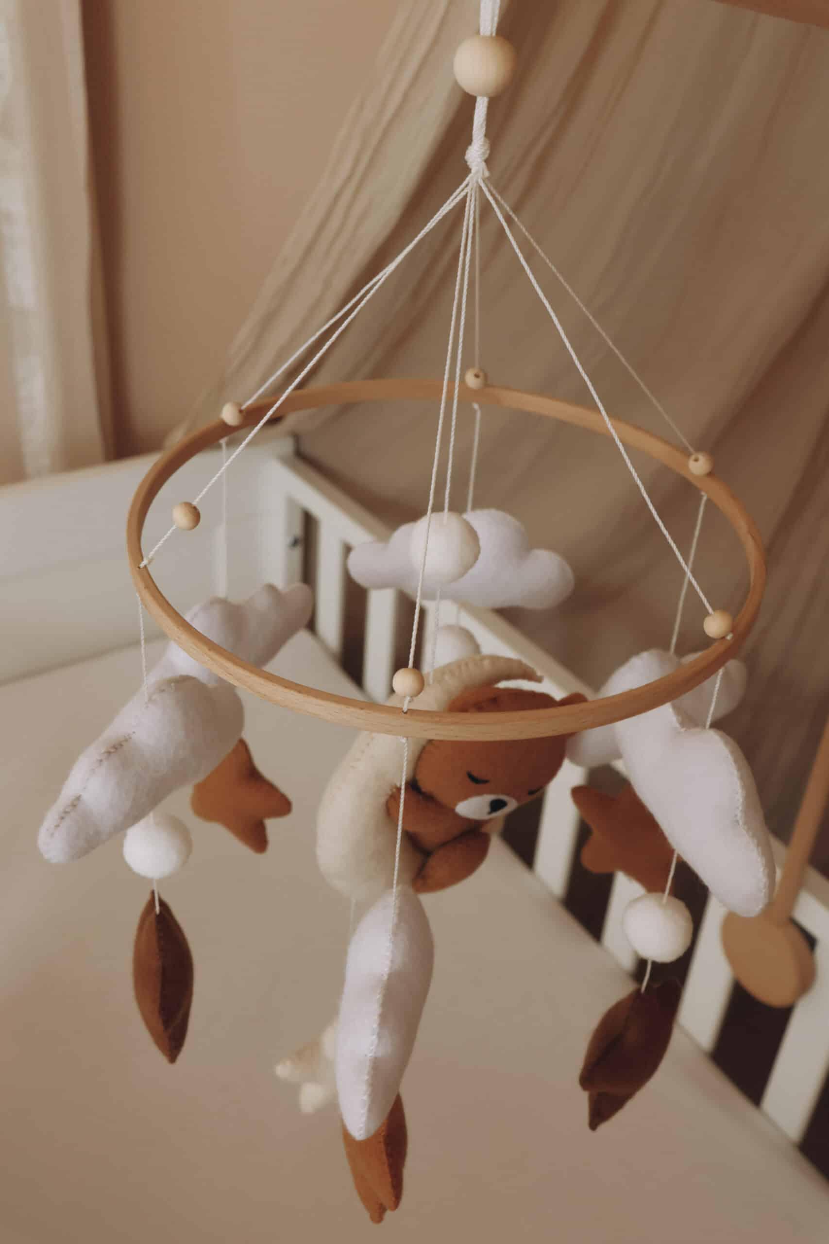 Mobile bébé en feutrine avec ours, nuages et étoiles, suspendu au-dessus d’un lit enfant